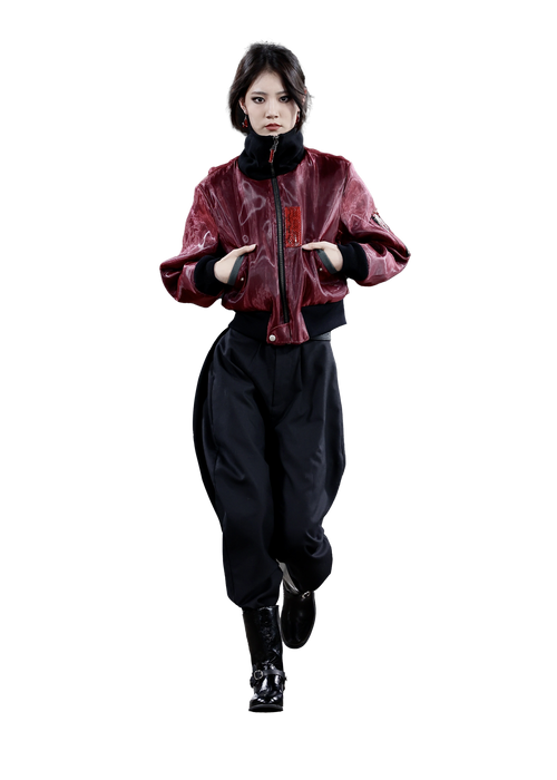 Person wearing a red jacket and black pants on a white background